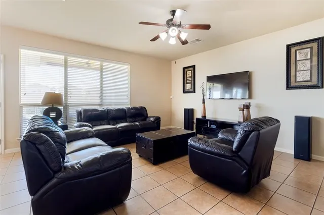 a living room with couch a dining table and a flat screen tv