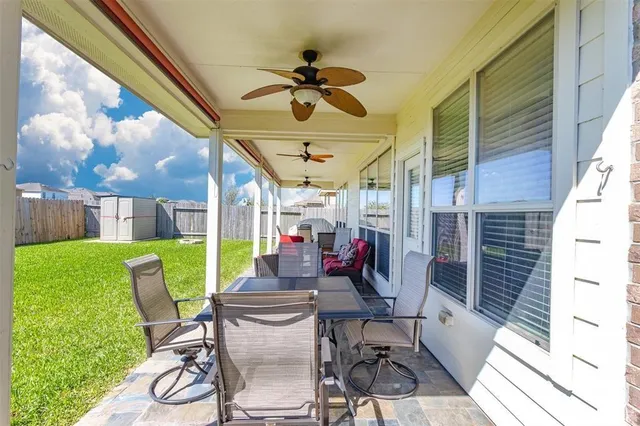 a view of a patio with a dining table and chairs with a garden