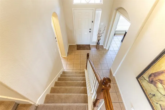 a view of staircase with railing and white walls