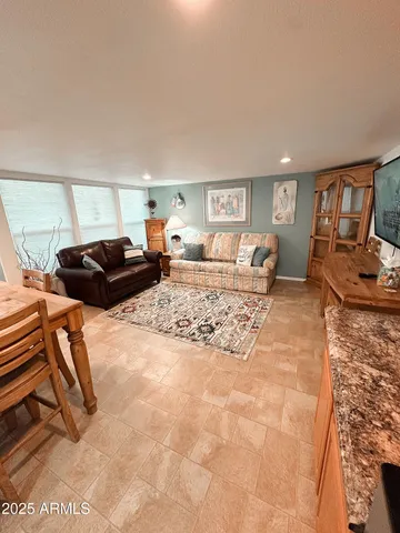 a living room with furniture and a dining table with kitchen view