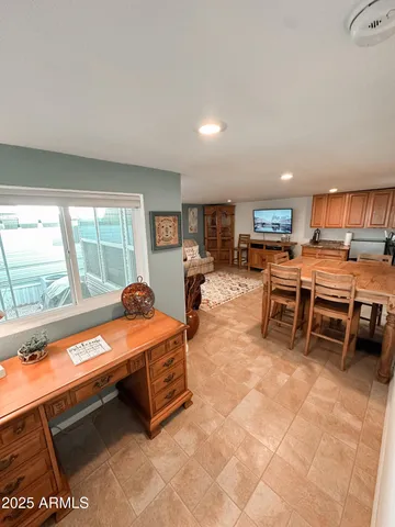 a living room with furniture a flat screen tv and a large window