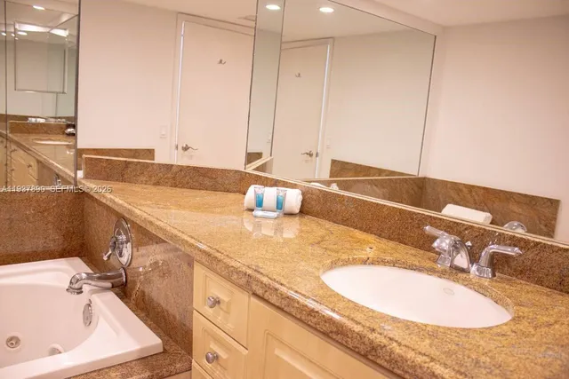 a bathroom with a granite countertop sink and a mirror
