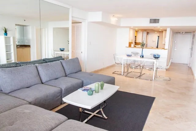 a living room with furniture a wooden floor and a chandelier