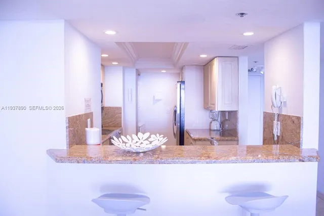 a bathroom with a granite countertop sink a toilet and a large mirror