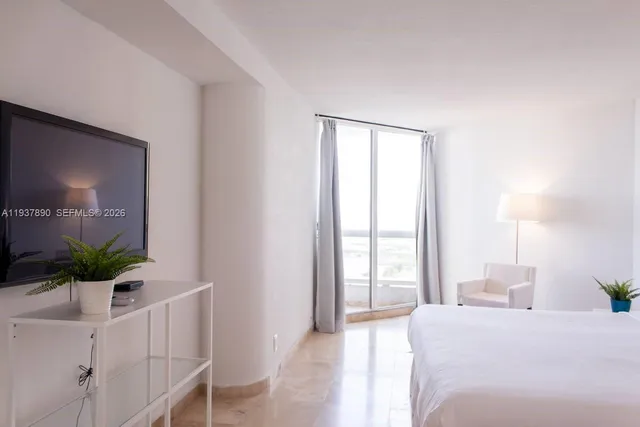 a bedroom with a large bed and a window