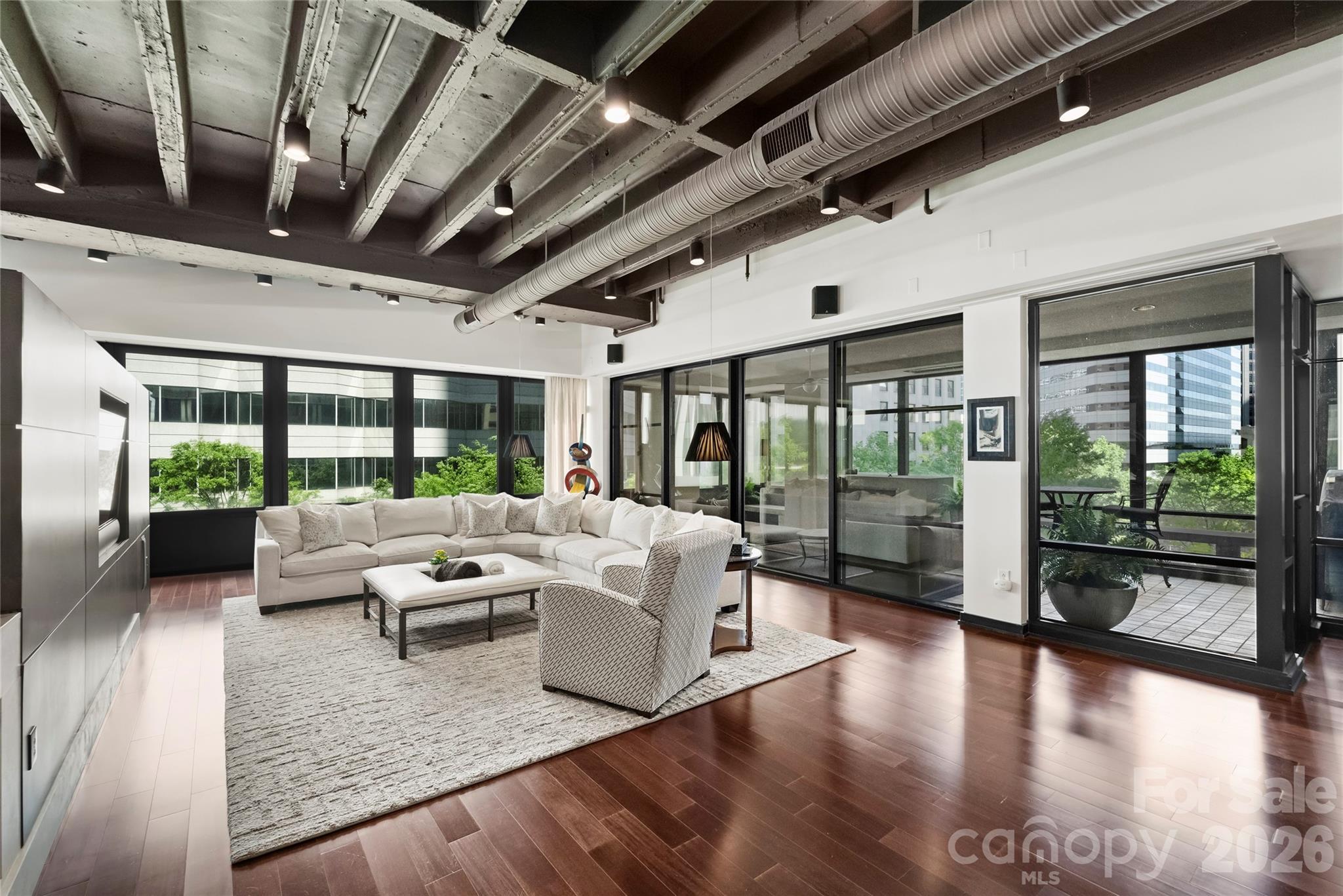 139 South Tryon Street, Unit 6 Charlotte, NC 28202 - Photo 6 of 47 a living room with furniture large windows and wooden floor