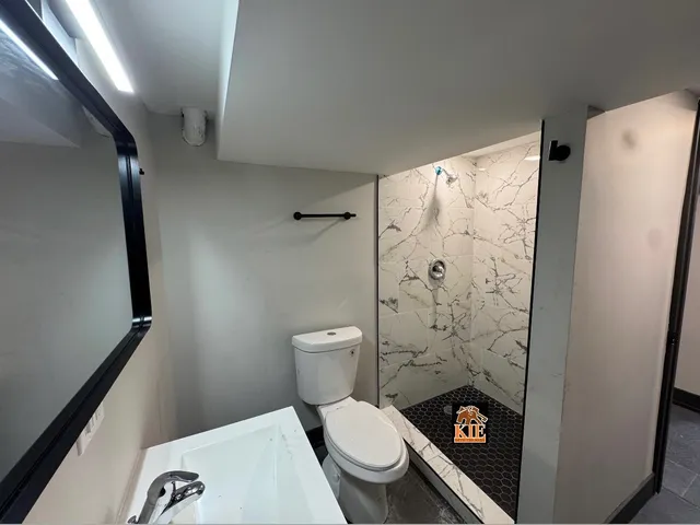 a bathroom with a toilet and a shower