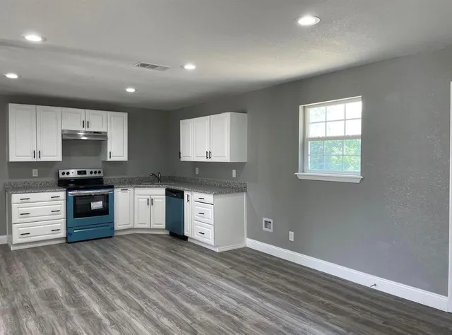 a kitchen with stainless steel appliances granite countertop a sink stove and cabinets