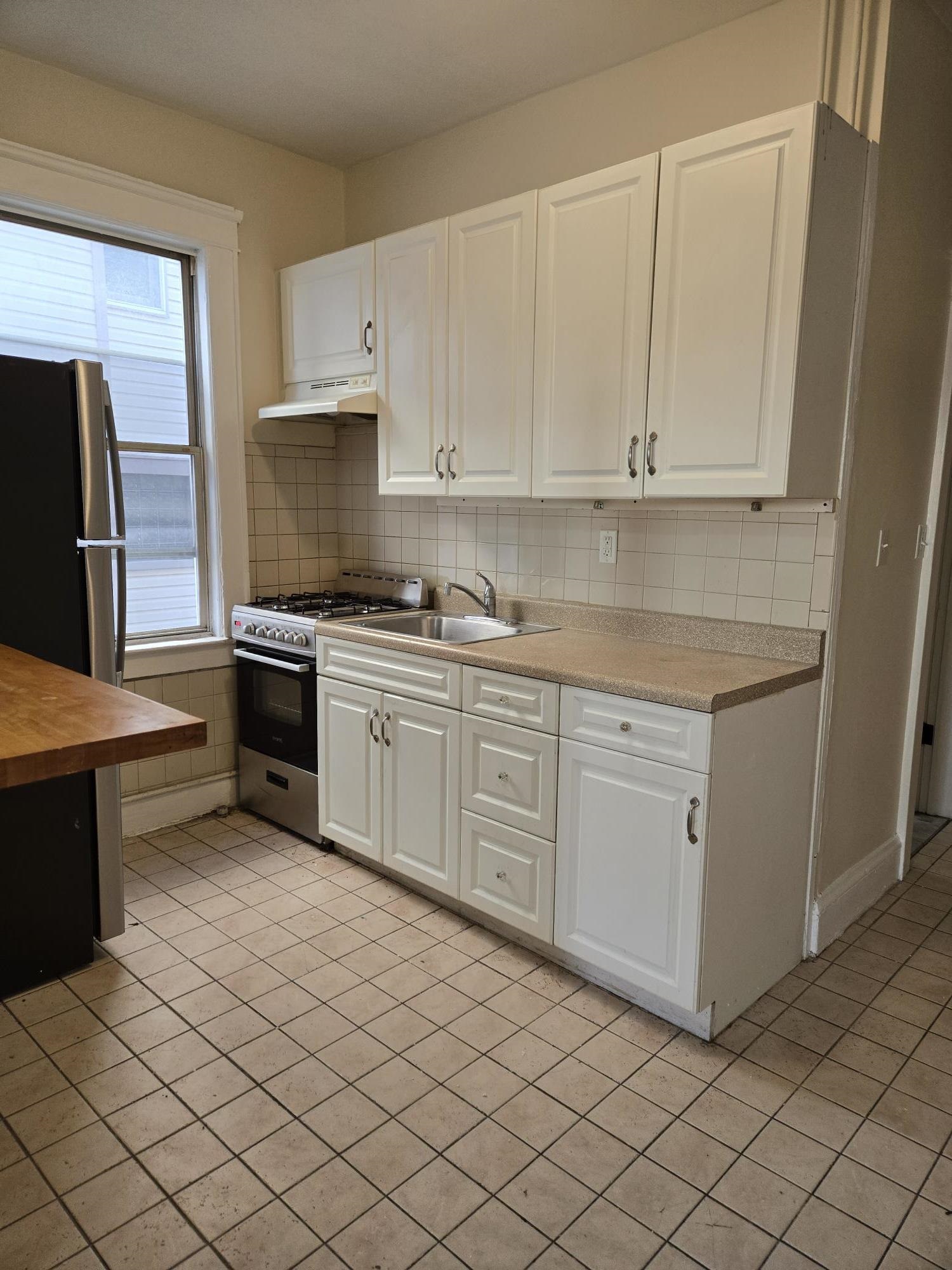 436 Anderson Avenue, Unit 4 Cliffside Park, NJ 07010 - Photo 2 of 7 a kitchen with white cabinets stainless steel appliances and sink