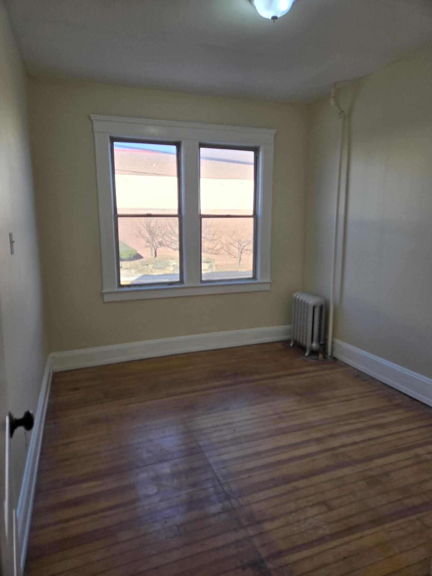436 Anderson Avenue, Unit 4 Cliffside Park, NJ 07010 - Photo 3 of 7 a view of an empty room with wooden floor and a window