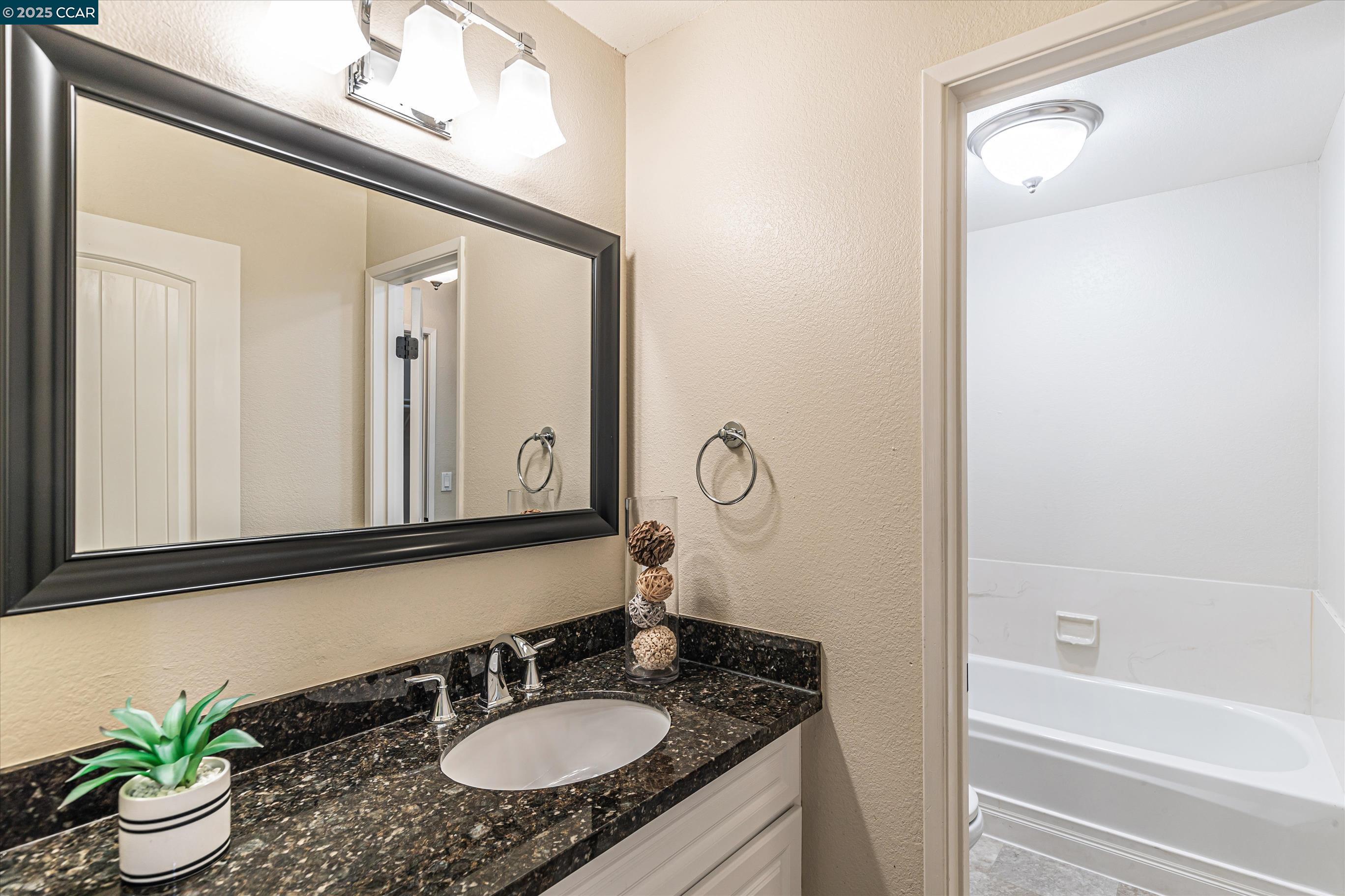 5055 Valley Crest Drive, Unit 196 Concord, CA 94521 - Photo 23 of 36 a bathroom with a granite countertop sink and a mirror