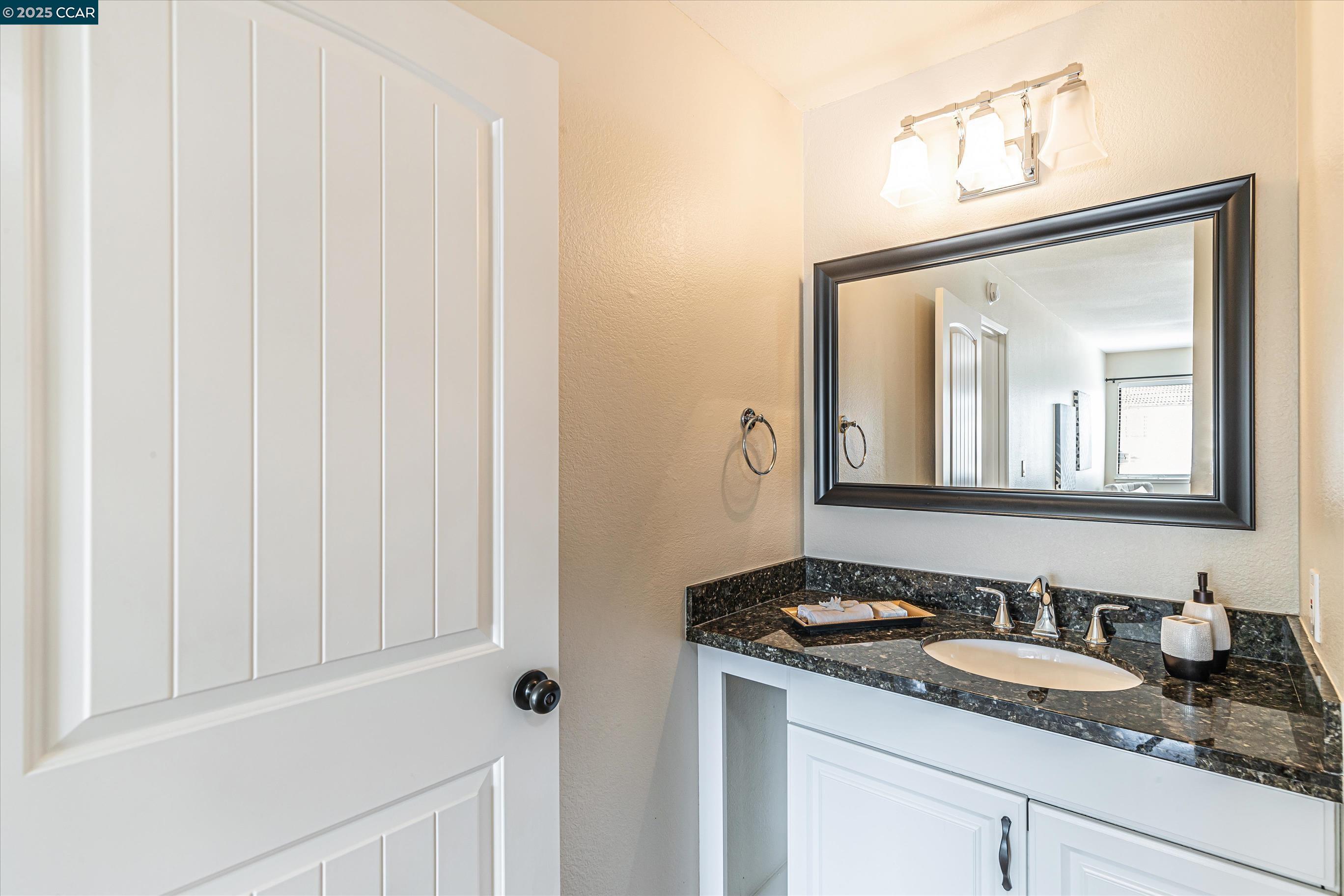 5055 Valley Crest Drive, Unit 196 Concord, CA 94521 - Photo 24 of 36 a bathroom with a granite countertop sink and a mirror
