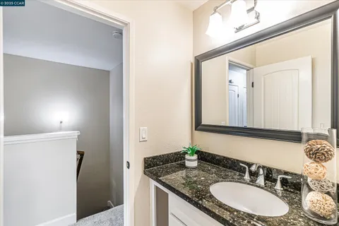 a bathroom with a granite countertop sink and a mirror