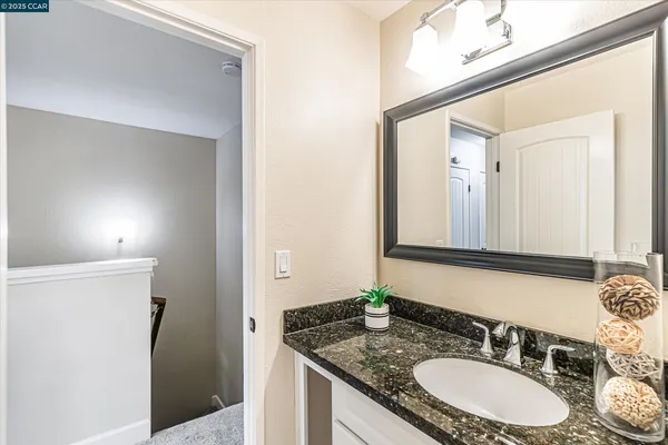 a bathroom with a granite countertop sink and a mirror