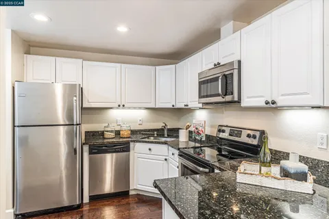 a kitchen with stainless steel appliances granite countertop a refrigerator stove microwave and sink