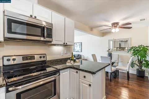 a kitchen with appliances a sink cabinets and wooden floor