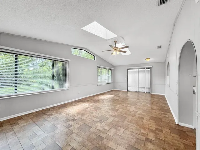 an empty room with windows and chandelier