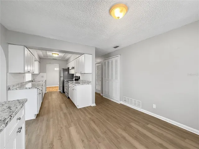 a view of kitchen with wooden floor and electronic appliances