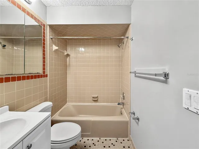 a bathroom with a shower a toilet and bathtub