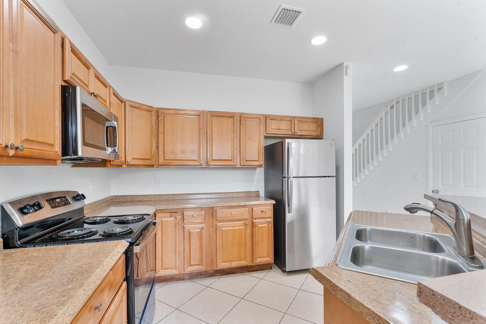995 Abaco Lane Riviera Beach, FL 33404 - Photo 4 of 34 a kitchen with stainless steel appliances granite countertop a refrigerator sink and stove