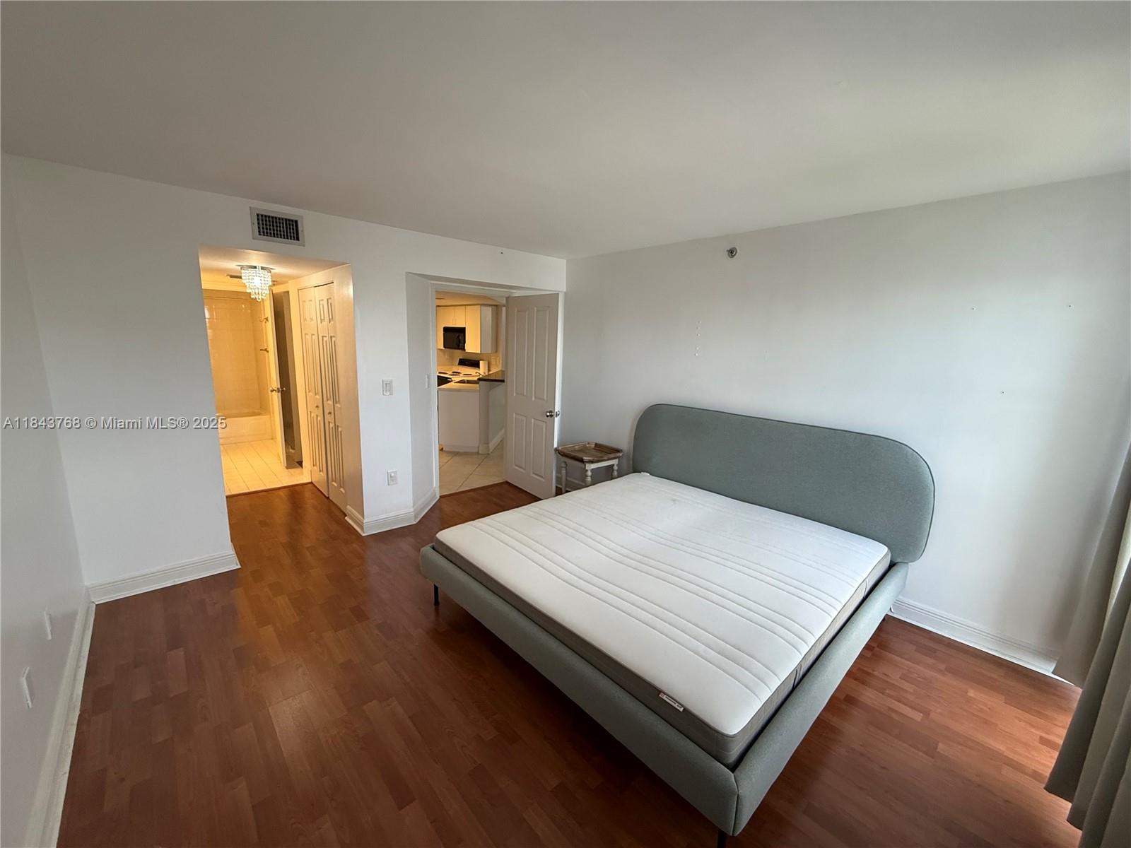 2351 Douglas Road, Unit 1208 Miami, FL 33145 - Photo 12 of 18 a bedroom with a bed and wooden floor