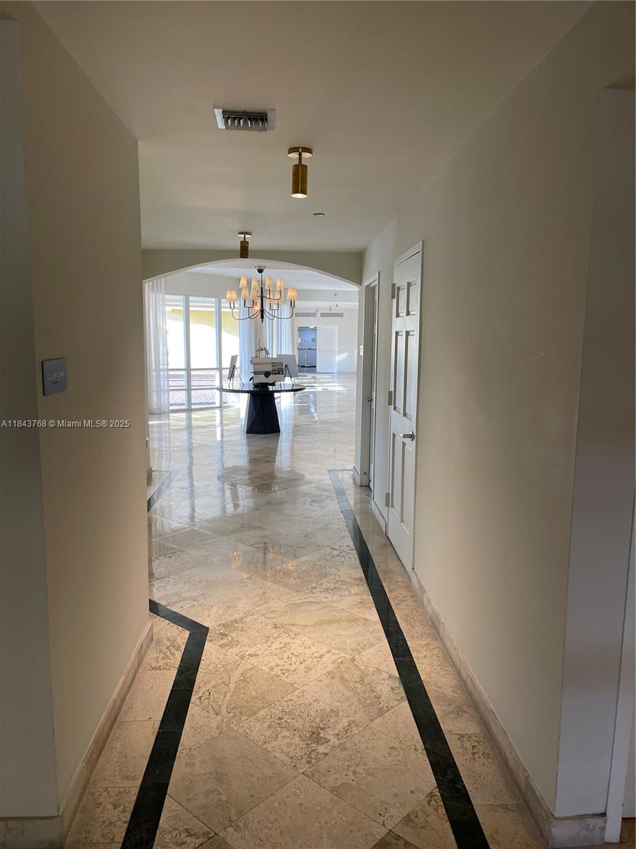 2351 Douglas Road, Unit 1208 Miami, FL 33145 - Photo 17 of 18 a view of a hallway with wooden floor and a fireplace