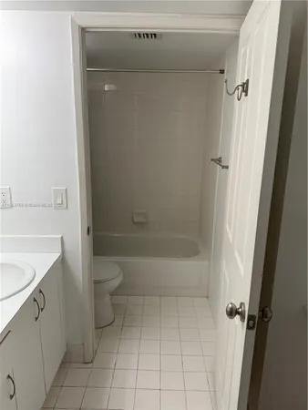 a bathroom with a granite countertop sink a toilet and shower