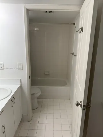 a bathroom with a granite countertop sink a toilet and shower
