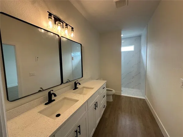 a bathroom with a sink and mirror with shower