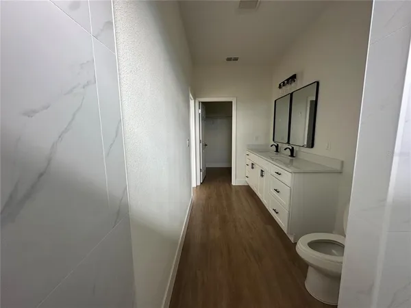 a bathroom with a granite countertop toilet sink and mirror