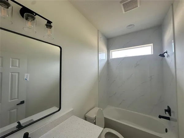 a view of an empty room with wooden floor and closet