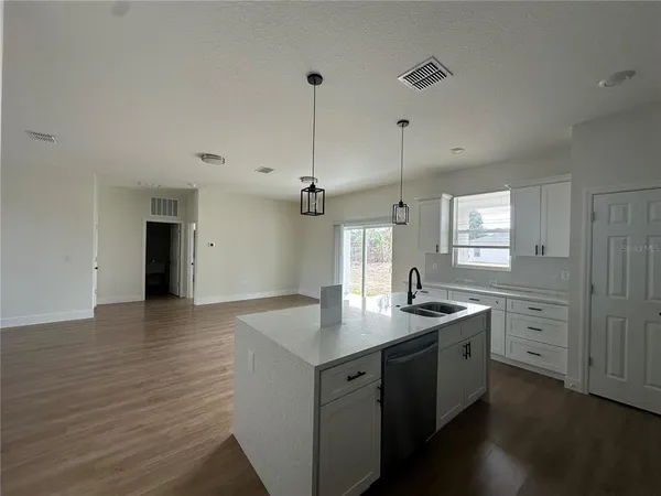 a kitchen with a sink cabinets and wooden floor
