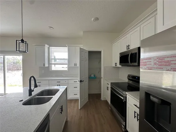 a kitchen with a sink stove top oven and refrigerator