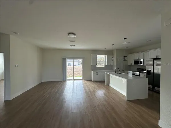 a view of kitchen with sink refrigerator and window