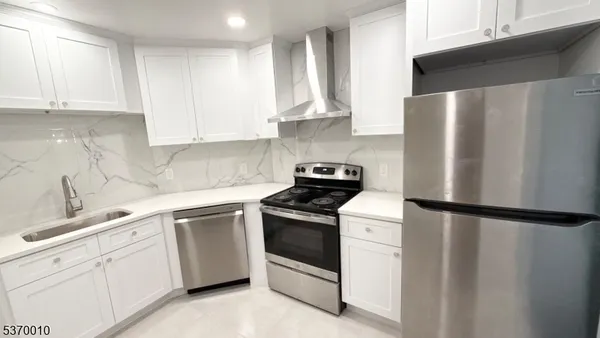 a kitchen with white cabinets and white appliances