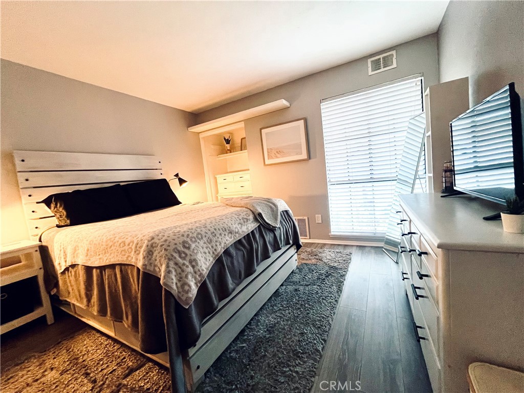 12635 Briarglen Loop, Unit K Stanton, CA 90680 - Photo 11 of 12 a bedroom with a bed and wooden floor