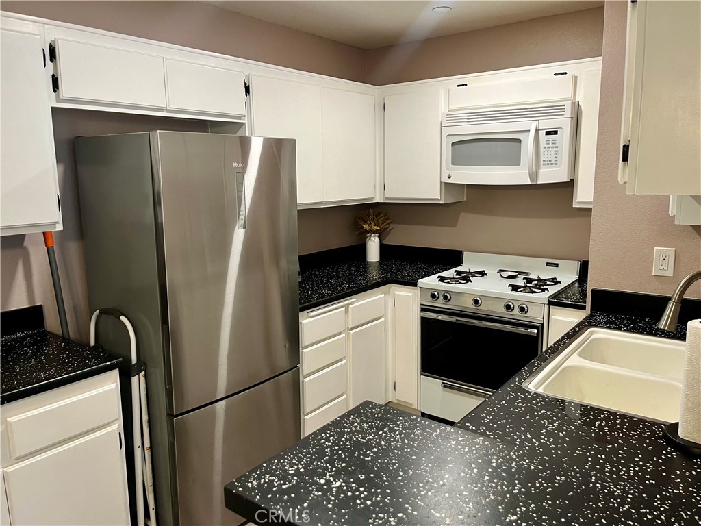 12635 Briarglen Loop, Unit K Stanton, CA 90680 - Photo 5 of 12 a kitchen with a refrigerator stove and sink