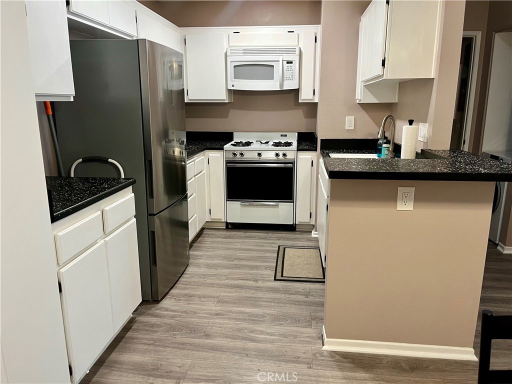 12635 Briarglen Loop, Unit K Stanton, CA 90680 - Photo 6 of 12 a kitchen with stainless steel appliances a refrigerator stove and sink