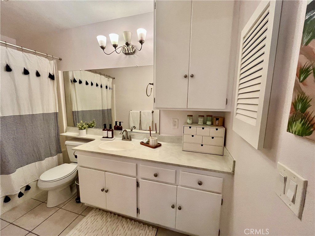 12635 Briarglen Loop, Unit K Stanton, CA 90680 - Photo 9 of 12 a bathroom with a double vanity sink a toilet and a window