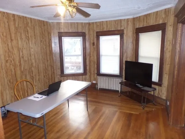 a living room with furniture a flat screen tv and a window
