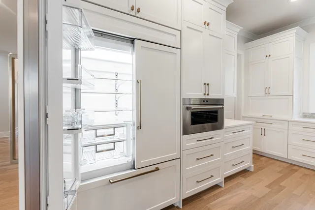 a kitchen with white cabinets and white appliances