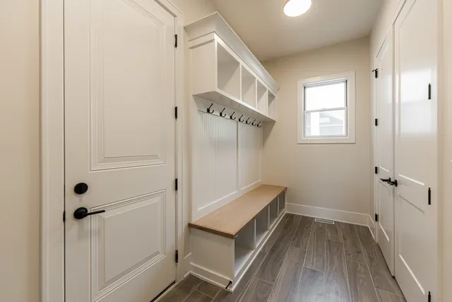a view of a hallway with entryway and wooden floor