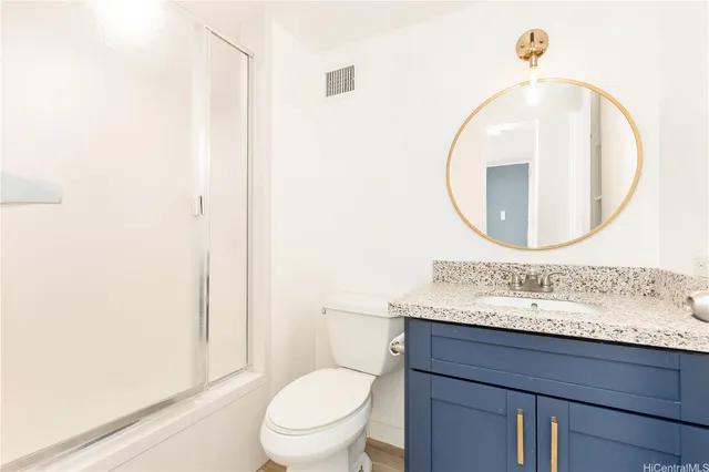 a bathroom with a toilet a sink and mirror