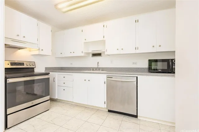 a kitchen with granite countertop white cabinets and stainless steel appliances