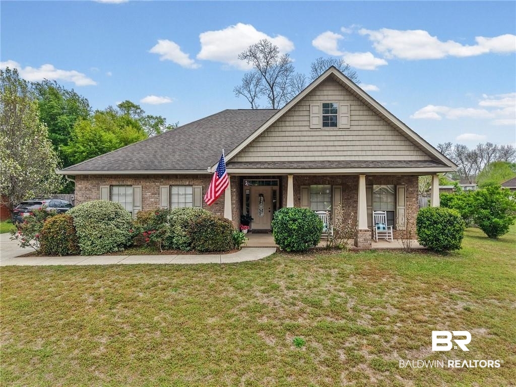 2570 Pecan Pointe Drive Semmes, AL 36575 - Photo 1 of 22 View of front of property featuring a front lawn, a porch, brick siding, and roof with shingles