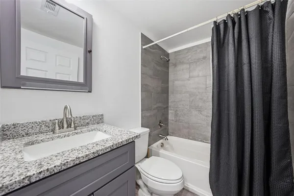 a bathroom with a granite countertop sink toilet and shower
