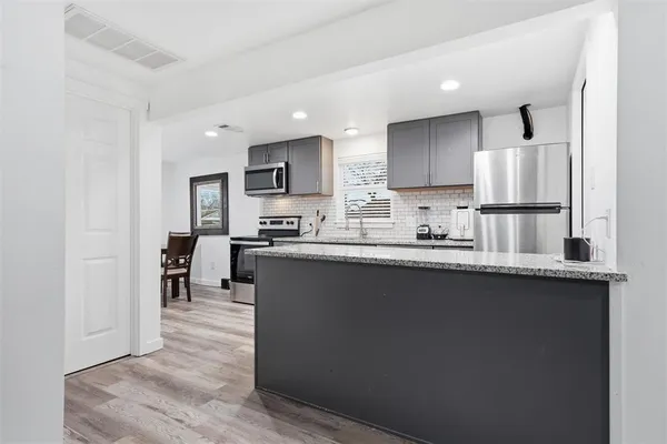 a kitchen with stainless steel appliances granite countertop a refrigerator sink and cabinets