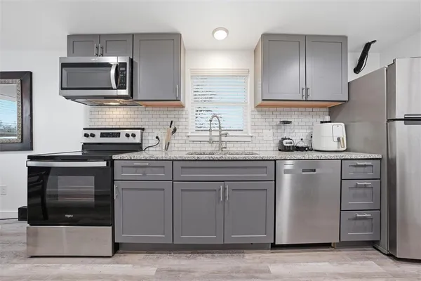 a kitchen with appliances a sink and cabinets