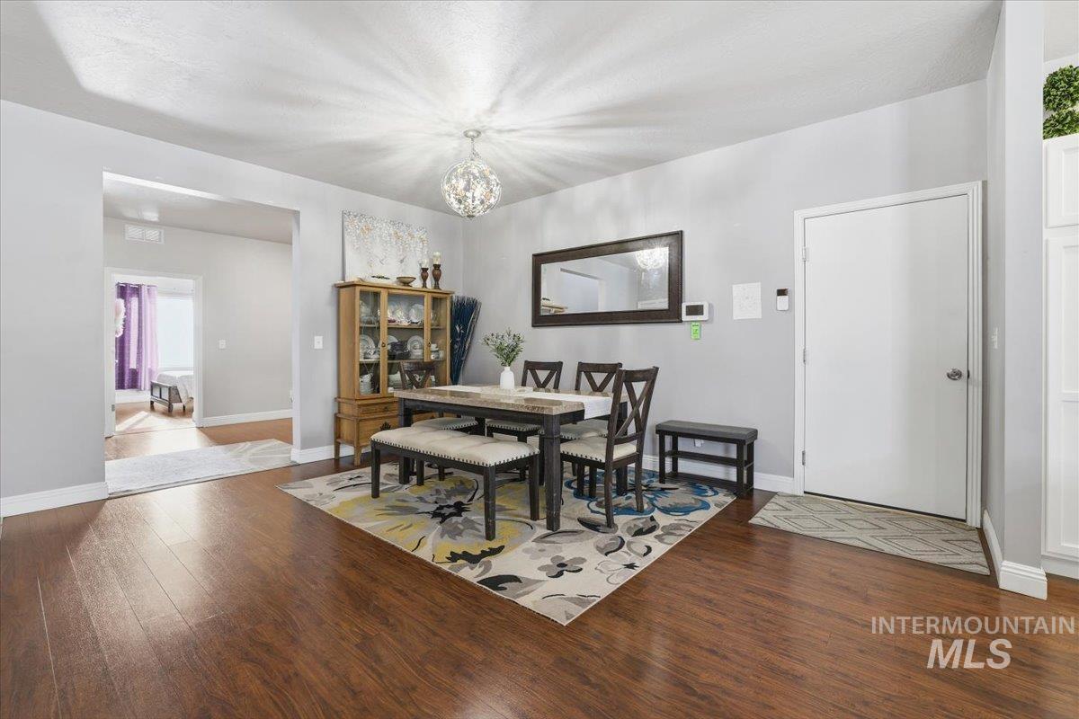 7501 West Swift Lane Boise, ID 83704 - Photo 14 of 50 Dining room with dark wood-style flooring and a chandelier
