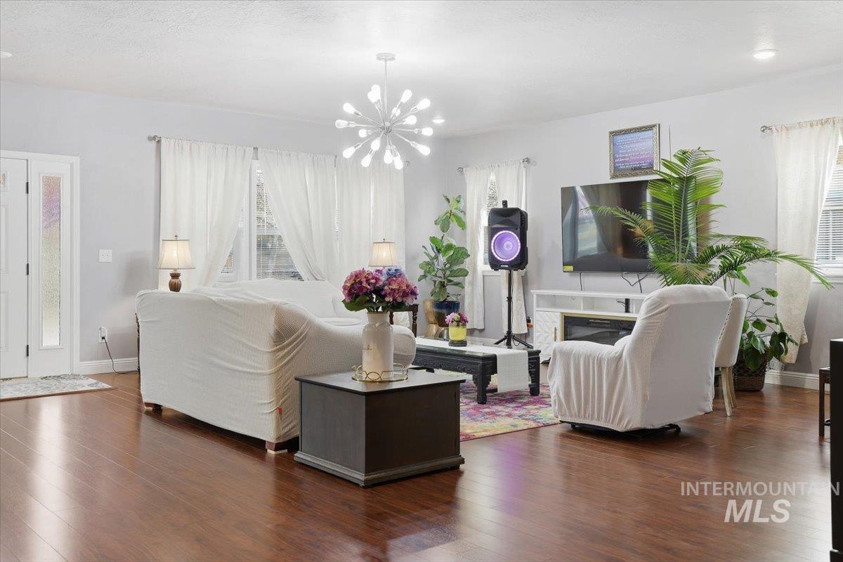 7501 West Swift Lane Boise, ID 83704 - Photo 7 of 50 Living room with wood finished floors and a chandelier